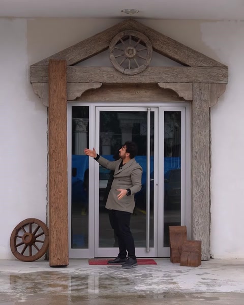 Bărbat instalează piesa finală roată decorativă la intrarea clădirii