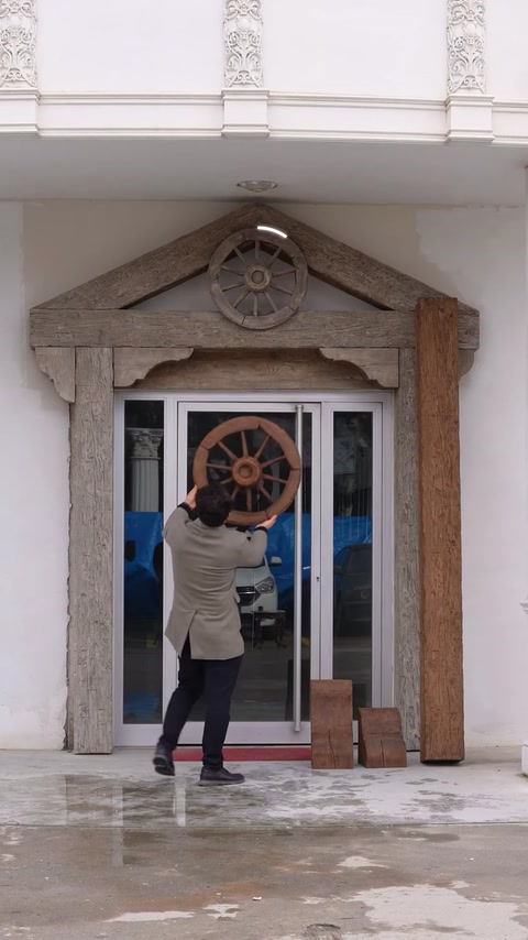 Ornamentul tip roată este poziționat în centrul frontonului decorativ.