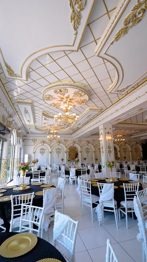 Tavanul casetat combină profile aurii, medalioane și candelabre elegante