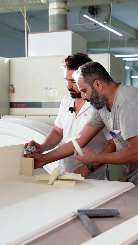 Specialiști ajustând componente albe pe masa de lucru din atelier