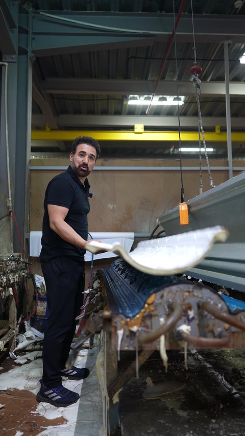 Lucrător prezentând un profil curbat lângă utilajul de producție