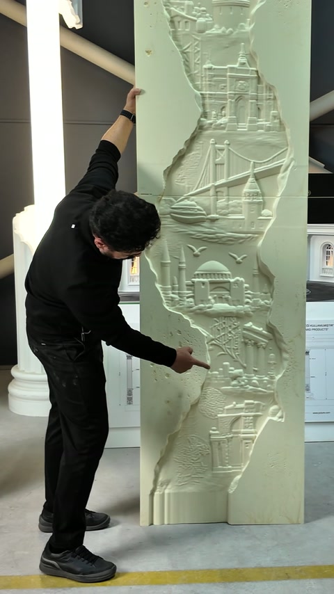Prezentatorul arată detaliile inferioare și marginile neregulate ale basoreliefului.