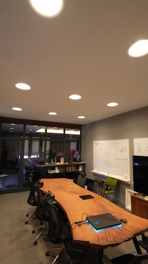 Birou modern luminat prin forme circulare integrate în plafon