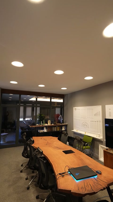 Sala de ședințe are plafon neted cu spoturi circulare încastrate.