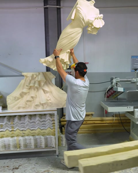 Muncitor ridică o piesă de poliuretan pe linia de producție din fabrică