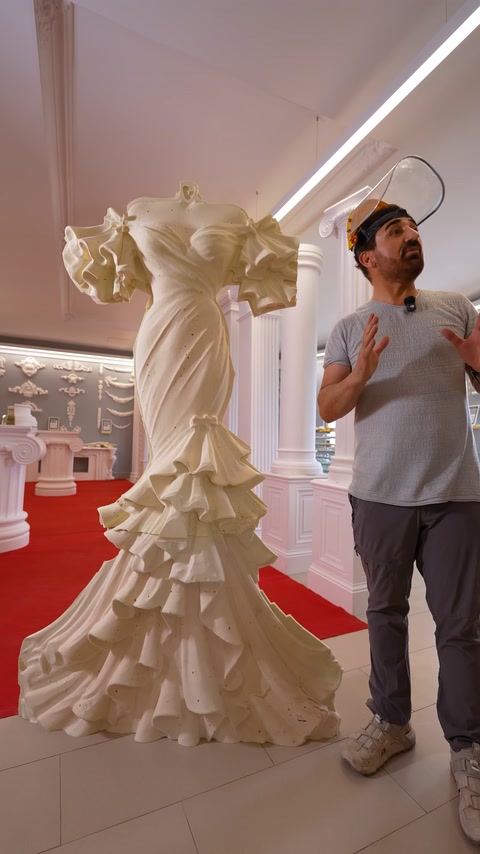 Prezentator explică lângă relieful complet al rochiei de mireasă